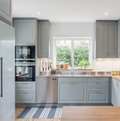 Denco31 Luxury Light Grey Shaker Kitchen Cabinets | Brass Hardware & Stainless Steel Countertops